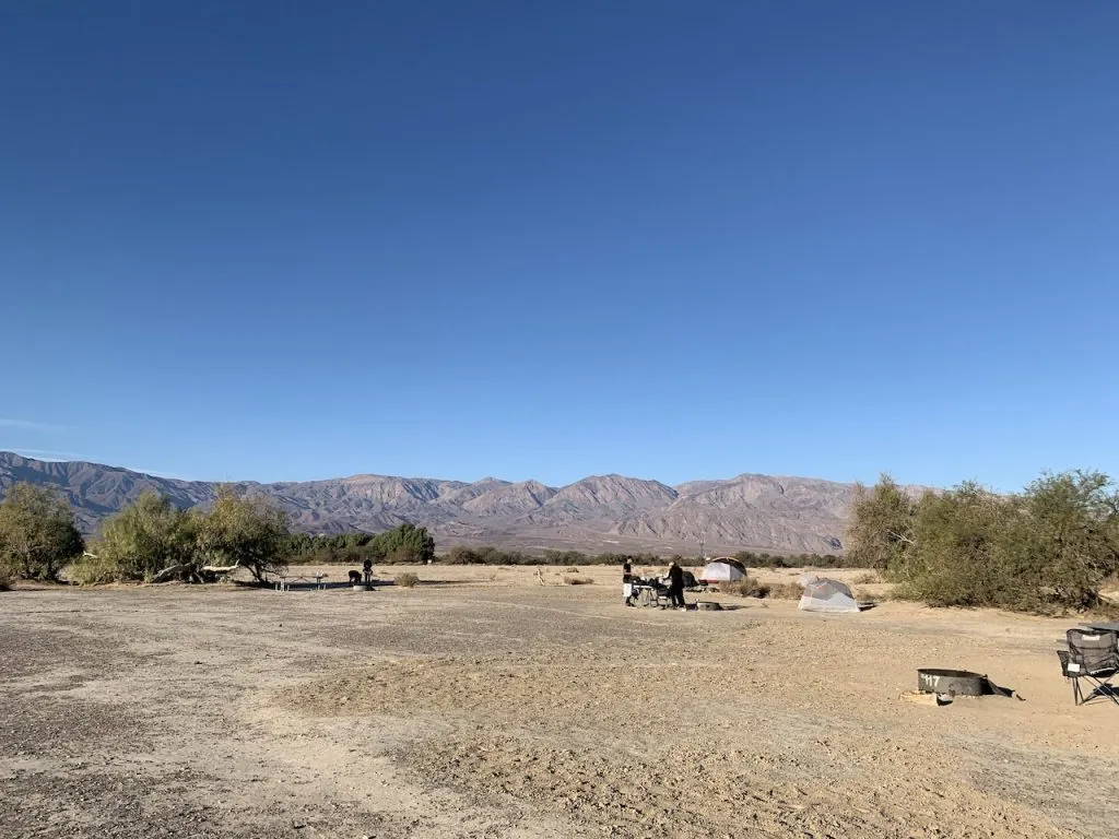 シエラネバダ山脈をバックに広大なデスバレー国立公園内にある砂漠キャンプ場があるファーニスクリークキャンプ場でキャンプを楽しんでいる人達。