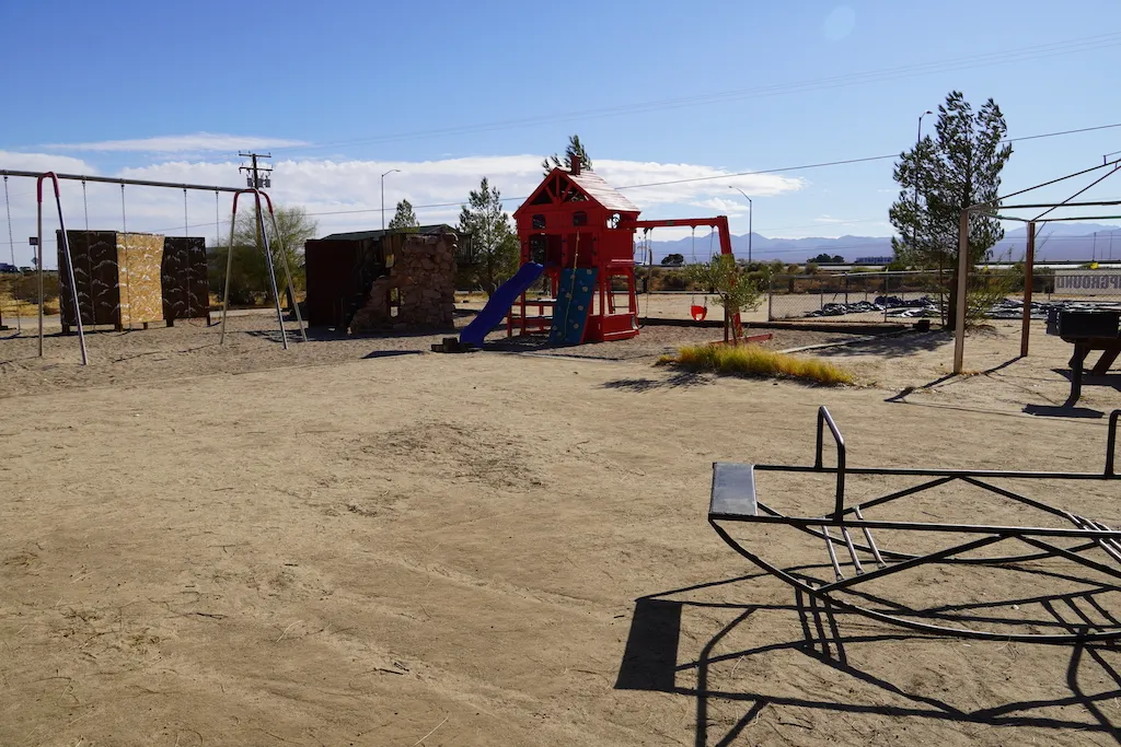 Play structures of swings, slide and rock climbing at KOA Barstow and Calico.
