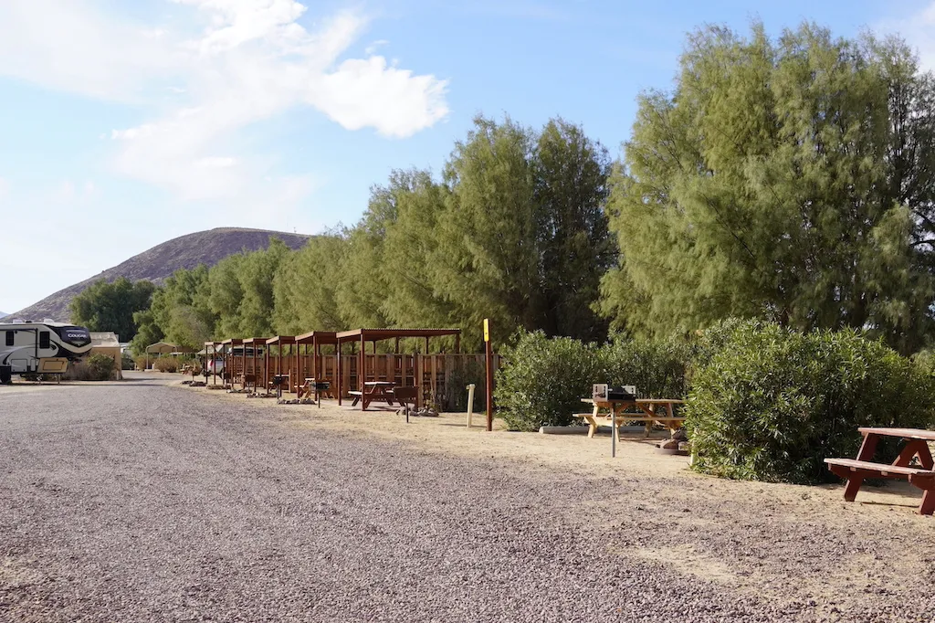 Tent sites with picnic benches along the path at KOA Barstow and Calico.