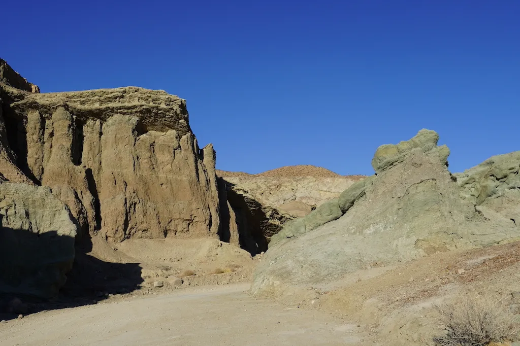A drive through course between hills made of naturally colorful dirt.
