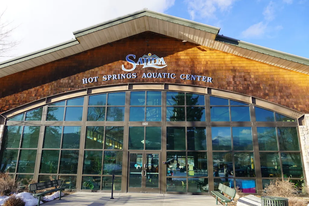 The pool building with glass door and windows of Hot Springs Aquatic Center in Salida, Colorado.