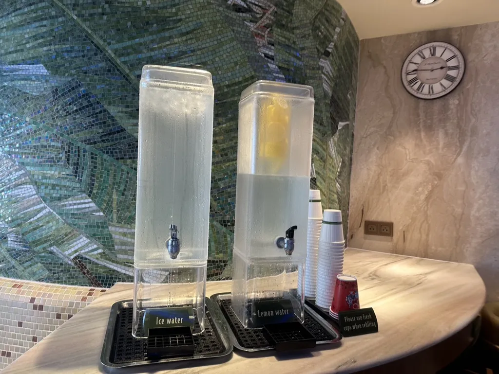Two water servers of Ice water and Lemon water at the counter table on Disney Cruise Dream Rainforest Club.
