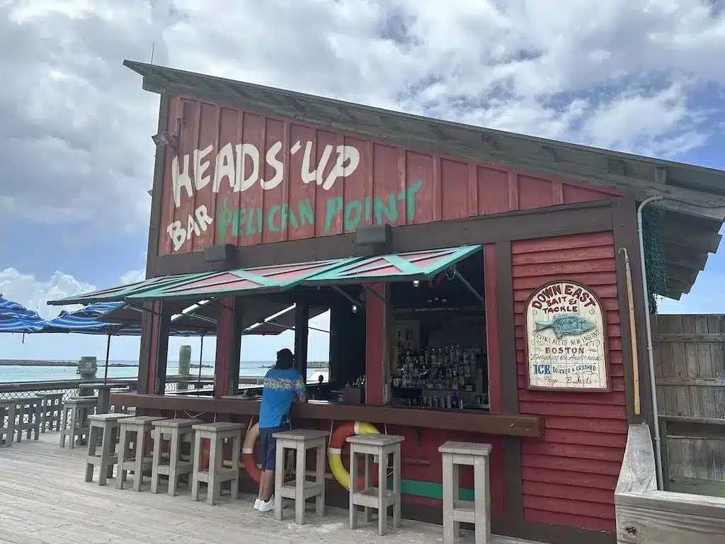 A bar in a red building with the sign "Head'Up Bar."