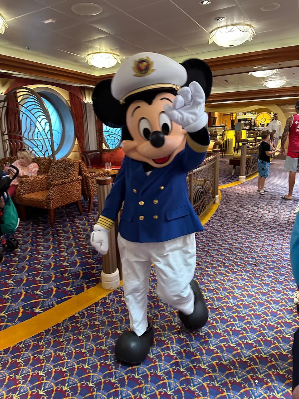 DCL_Mickey_Captain - Tomo Travel & Camping Captain Mickey is waving inside the Disney Cruise Ship.