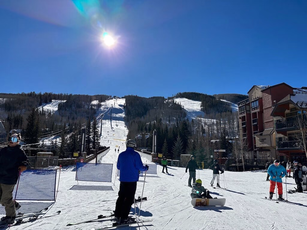 Skiers gliding down Vail's pristine, snow-white slopes.