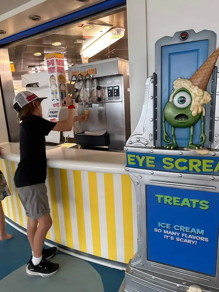 Eye Scream station on the Disney Dream cruise ship, where guests can enjoy unlimited self-serve soft-serve ice cream. The playful station is inspired by Monsters, Inc. and offers various flavors for guests to create their own treats anytime during the day.