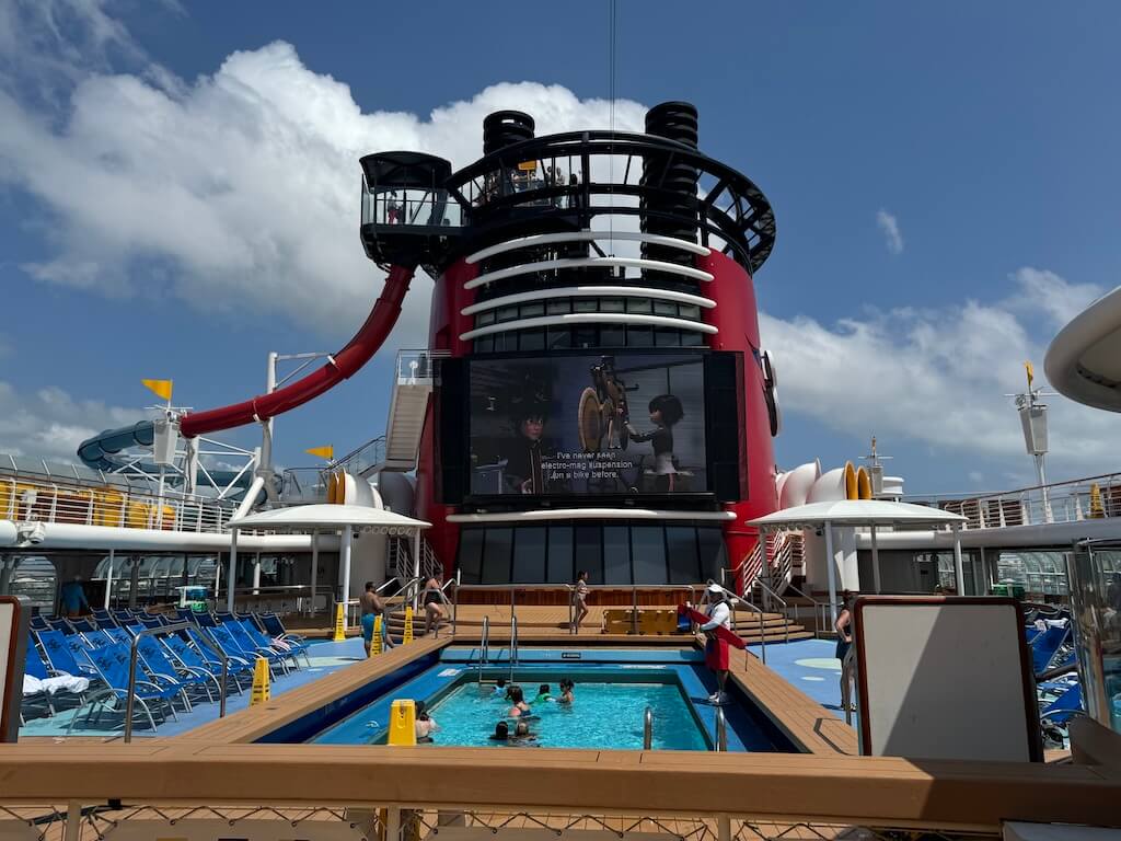 DCL_Magic Pool Movie - Tomo Travel & Camping People are watching Disney movies from the kids pool on Disney Cruise Magic.
