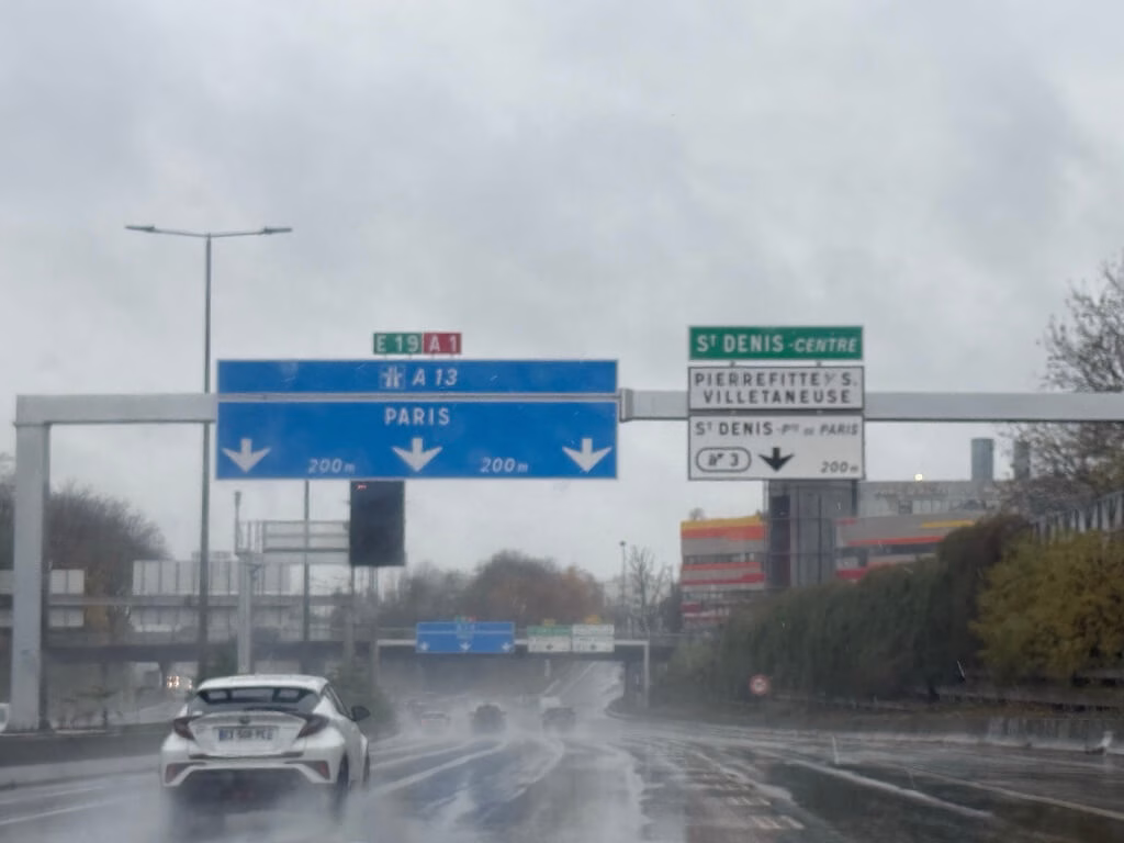 雨の降るなかパリ市内へと走るタクシーからの景色