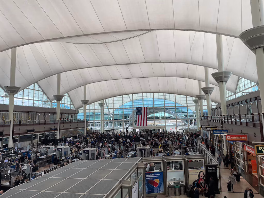 The Versailles gardens, viewed from the palace, are a stunning display of French formal design, featuring symmetrical lawns, vibrant flower beds, sculpted hedges, and shimmering fountains that blend gracefully into the horizon.
