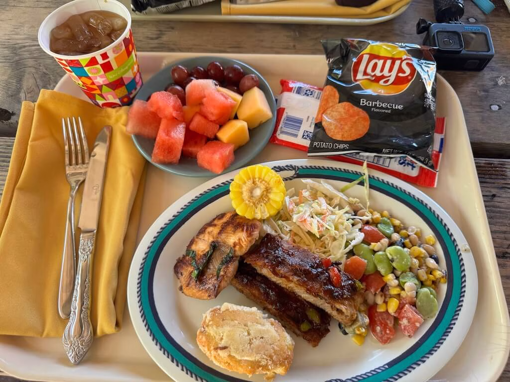 At Castaway Cay, you can enjoy a tasty BBQ lunch featuring classics like hamburgers, BBQ ribs, and hot dogs, along with refreshing sides like salads and fresh fruit.