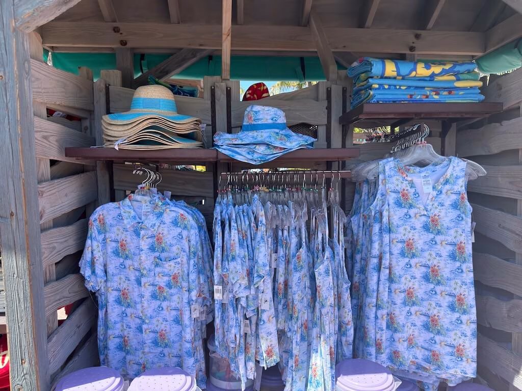 People entering the gift shop at Castaway Cay under a clear blue sky.