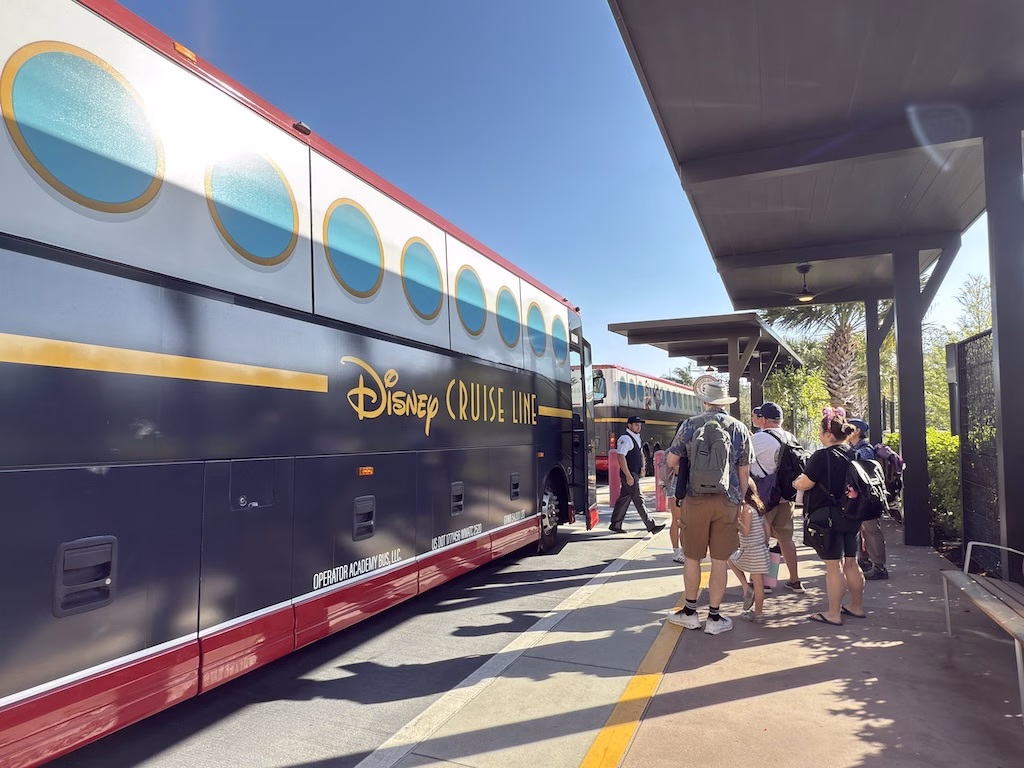 Guests boarding the Disney Cruise Line Shuttle bus at a Disney Resort, heading to Port Canaveral on a sunny day