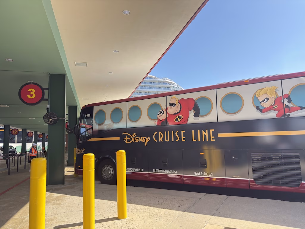 Disney Cruise Line Shuttle bus with Incredibles-themed design parked at Port Canaveral cruise terminal loading zone