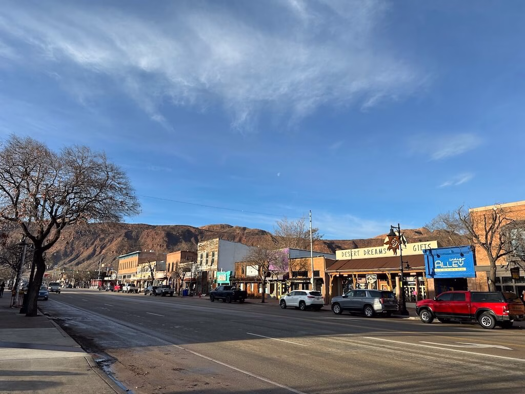 ユタ州モアブのメインストリート。赤い岩山を背景に、お土産店やカフェが立ち並ぶ落ち着いた町並みが広がる。