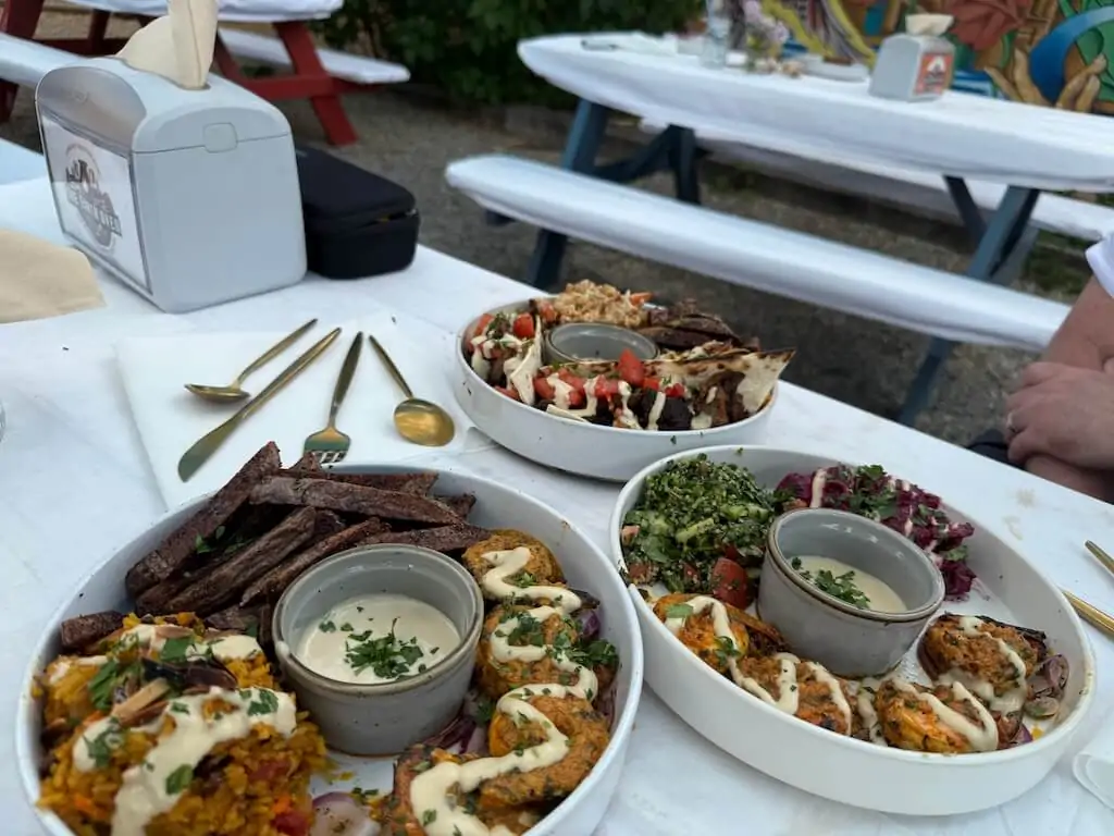 Colorful Mediterranean lunch plates with falafel, hummus, and vegetables served at Alys A La Cart food truck in Taos, New Mexico.