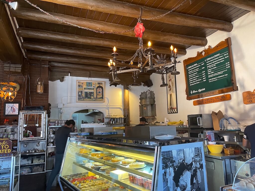 The French Pastry Shop Santa Fe – A Cozy Café Stop When Exploring Where to Go in Santa Fe - Tomo Travel & Camping ニューメキシコ州サンタフェにあるフレンチ・ペストリー・ショップの店内。ヨーロッパ風の趣ある雰囲気と新鮮なペストリーが並ぶ、朝食やブランチにぴったりの居心地の良いカフェ
