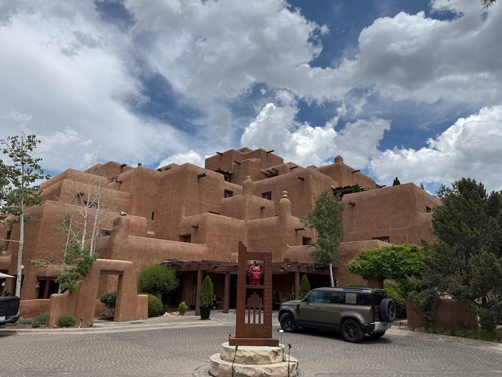 Inn and Spa at Loretto – Adobe Elegance in the Heart of Santa Fe - Tomo Travel & Camping ニューメキシコ州サンタフェのイン&スパ・アット・ロレットのアドビ様式の外観。多層構造が印象的で、歴史地区や人気観光スポットにも近い静かな南西部の雰囲気が魅力