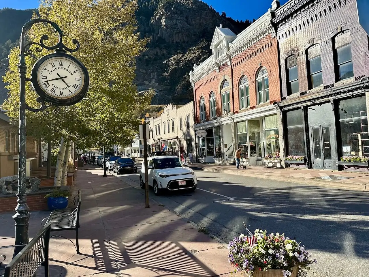 Historic downtown Georgetown, Colorado, with old brick buildings, boutique shops, street clock, and mountain views — a popular stop on Guanella Pass scenic drive.