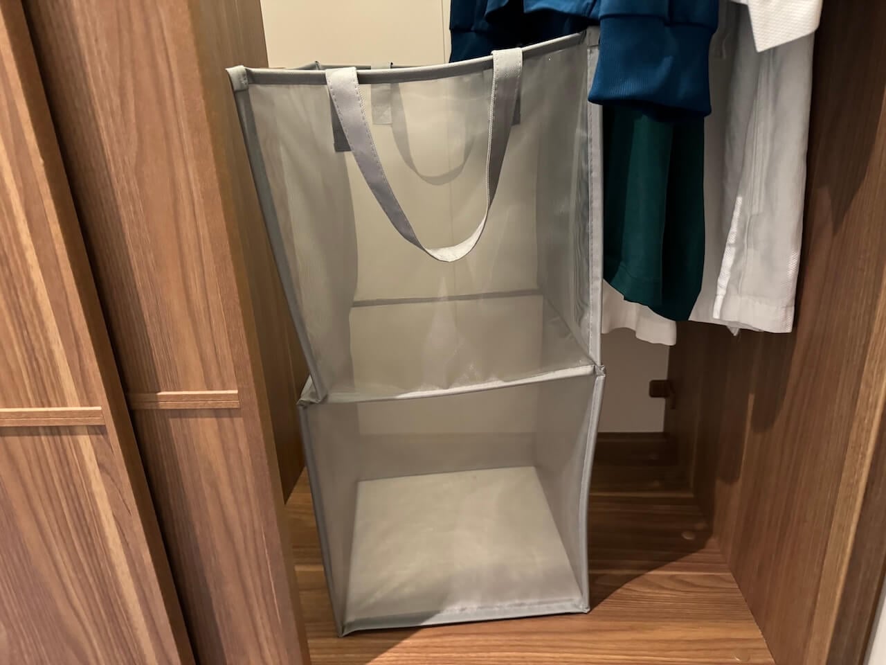 Disney Cruise Packing List Essential: Pop-up Laundry Hamper for Cruise Stateroom Organization - Tomo Travel & Camping ディズニークルーズの客室クローゼットに置かれた折りたたみ式ランドリーバッグ。使用済みの衣類や水着を整理できる便利な収納アイテム。