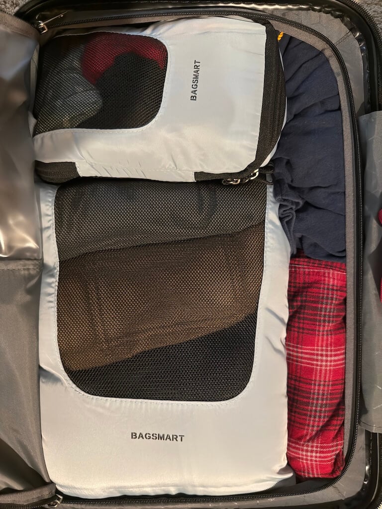 Disney Cruise Packing List Hack: Use Packing Cubes for Easy Stateroom Organization - Tomo Travel & Camping ディズニークルーズ旅行の荷造りで使うグレーと黒のパッキングキューブ(BAGSMART製)。衣類をきれいに仕分けてスーツケース内を整理整頓。
