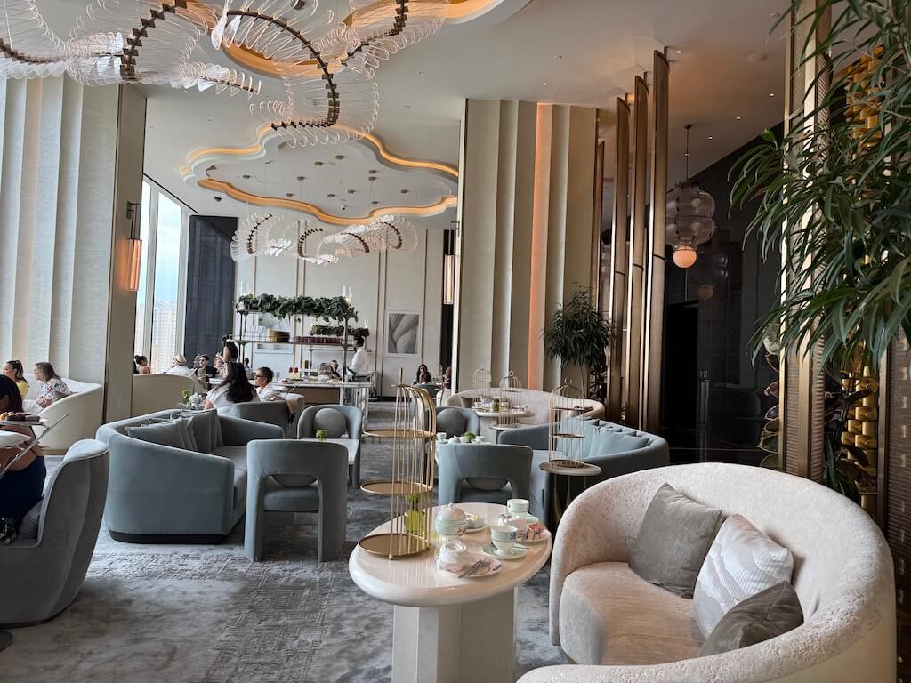 Afternoon Tea at Waldorf Astoria Las Vegas – Peacock Alley Lounge with Strip Views - Tomo Travel & Camping ウォルドルフ・アストリア・ラスベガスのエレガントな「ピーコック・アレー」ラウンジ。快適なソファ席とラスベガスの街並みを望む空間で、三段トレーのアフタヌーンティーを提供。
