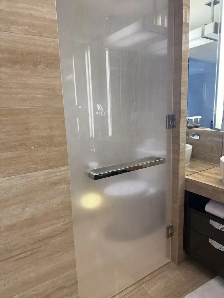 ウォルドルフ・アストリア・ラスベガスのバスルーム内にある、すりガラスのドアで仕切られたトイレ。