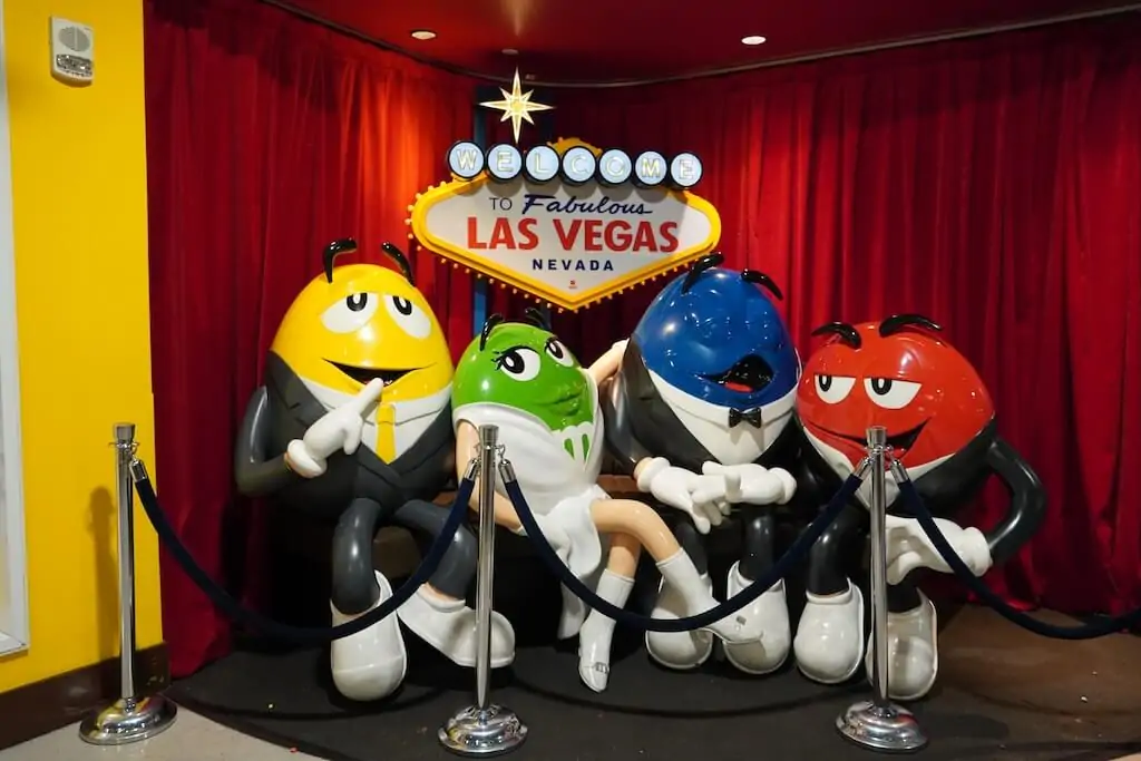 Life-size M&M’s characters posing in front of the "Welcome to Fabulous Las Vegas" sign inside M&M’s World