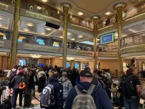 ディズニークルーズ下船日の朝、ロビーにスーツケースを持ったゲストが集まり混雑している様子