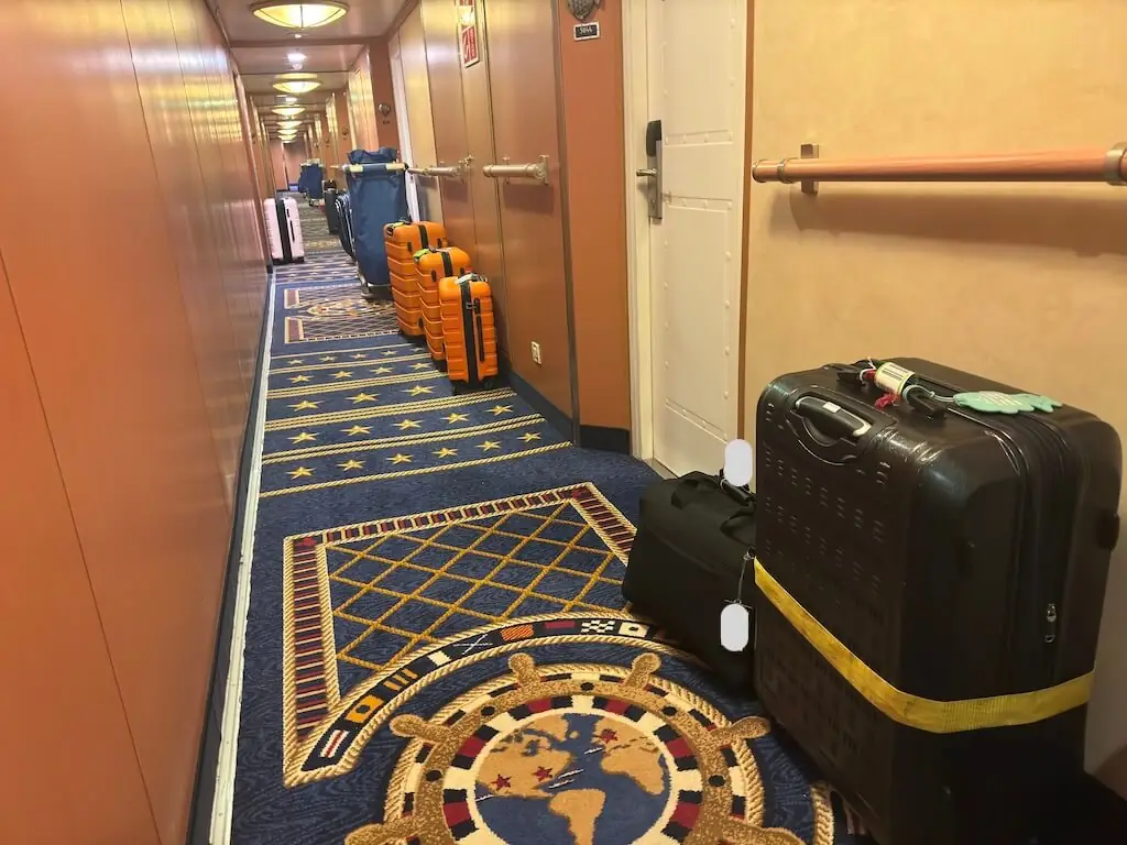 ディズニークルーズ下船前夜に客室前の廊下へ出されたスーツケースと荷物の様子