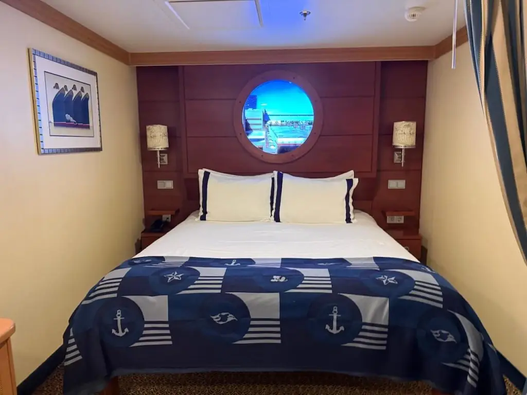 Disney Cruise inside stateroom with queen bed and porthole window, typical layout for an interior cabin or GTY guarantee room.