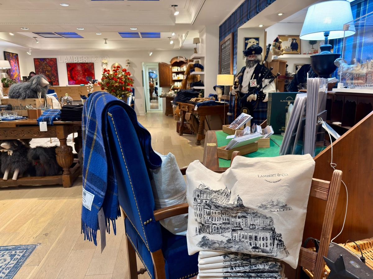chateau-frontenac-boutique - Tomo Travel & Camping Cozy shop interior with blue blankets, pillows, and lifestyle gifts displayed on wooden tables and shelves.