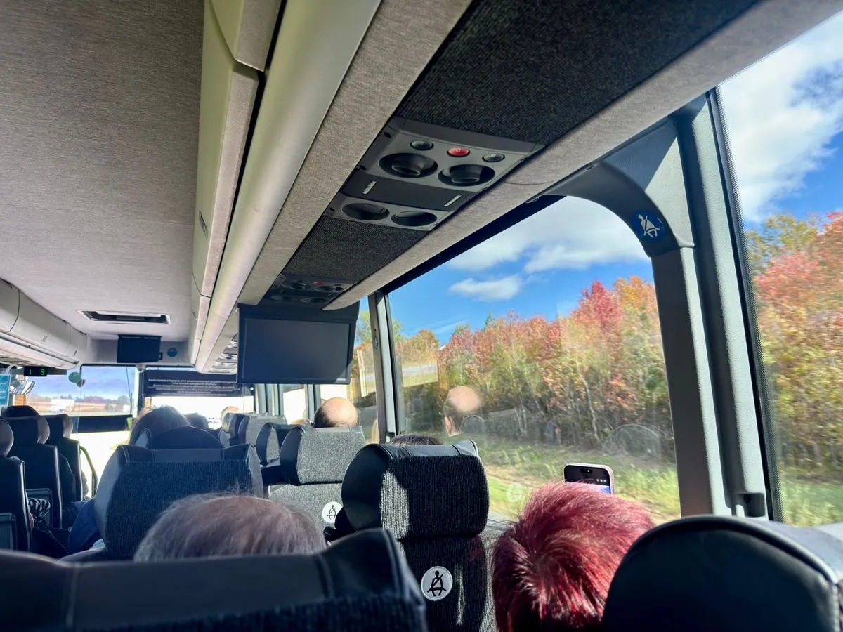 Inside the Orléans Express bus from Montreal to Quebec City, with fall colors outside the window