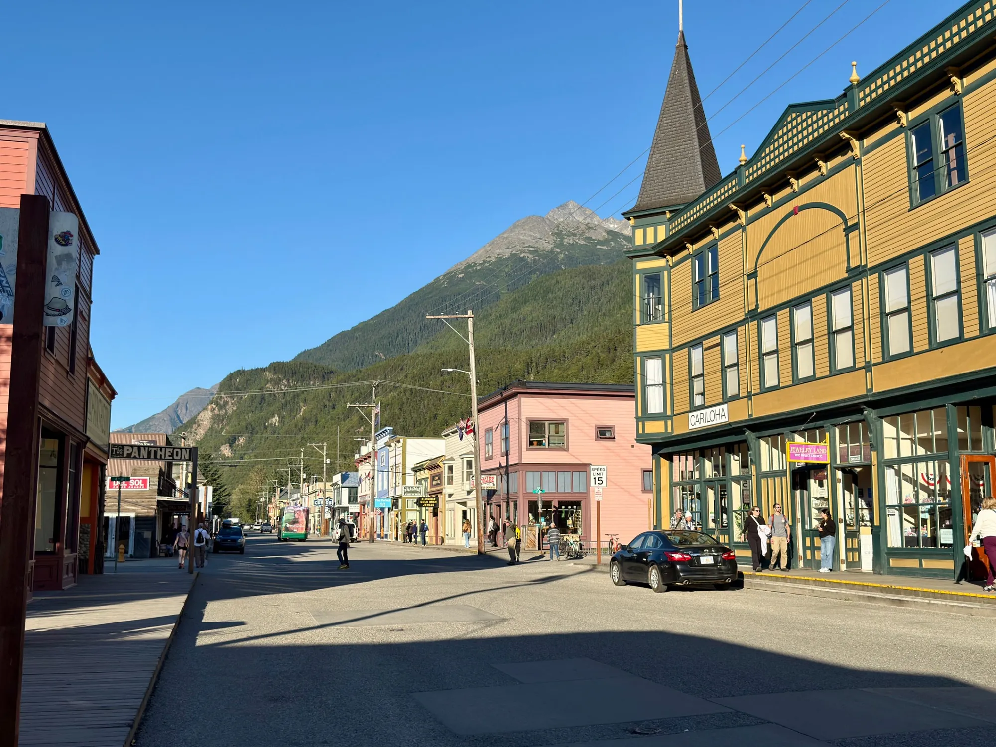 Colorful historic buildings along the main street of downtown Skagway, Alaska, under a clear blue sky